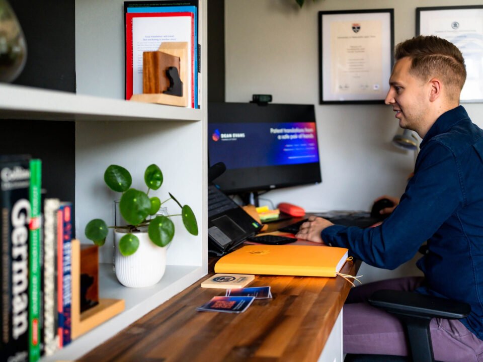 An image of Dean Evans working at his computer. The computer background reads "Patent translations from a safe pair of hands"